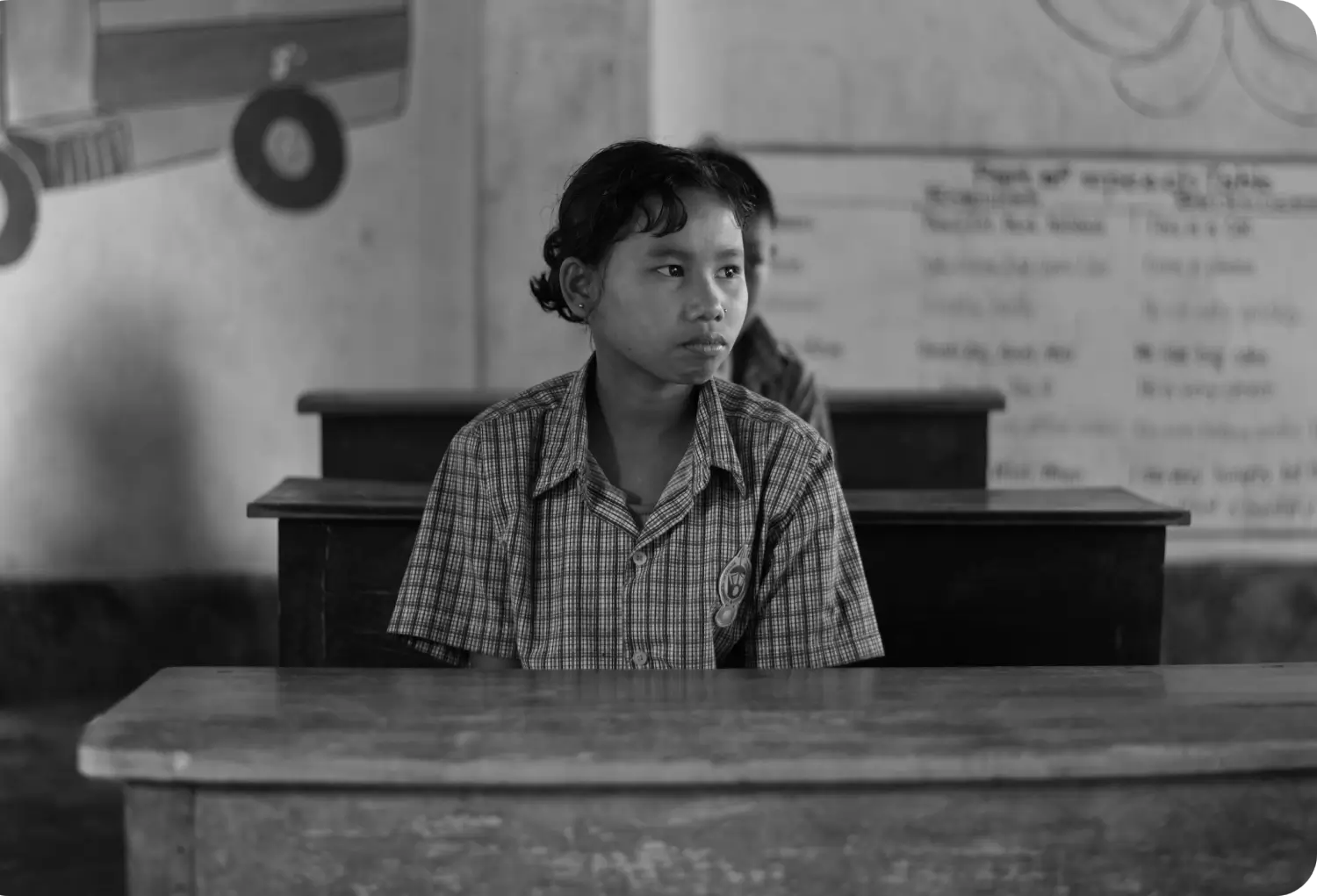 A smiling schoolgirl outdoors, representing the public school systems where Labhya's wellbeing program is delivered at scale